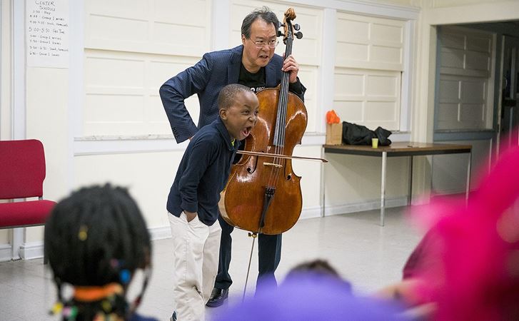 Ma collaborates with a student during an impromptu performance at RefugeeOne in the Uptown neighborhood.