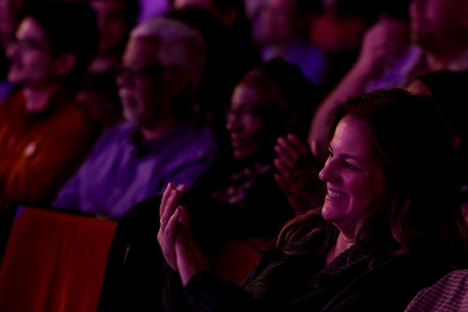 Audience members applauding from their seats