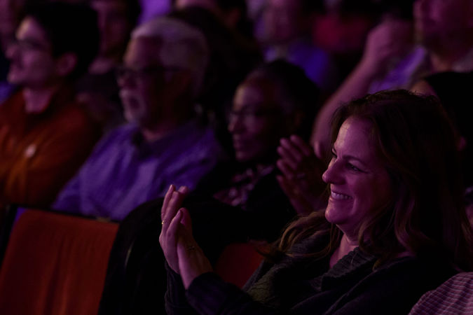 Audience members applauding from their seats