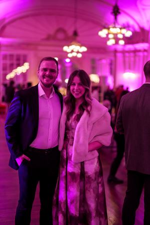 a couple pose in Grainger Ballroom decorated in pink for Valentine's Day