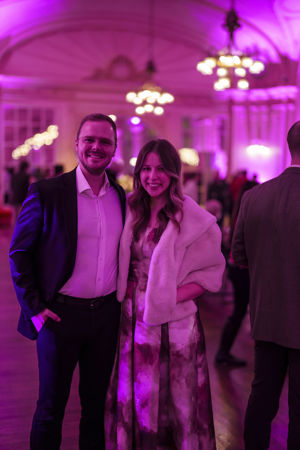 a couple pose in Grainger Ballroom decorated in pink for Valentine's Day