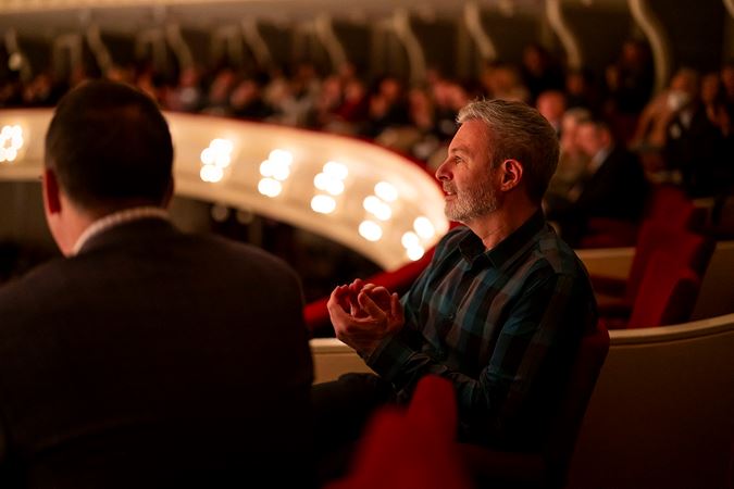 audience members in the box level applaud the ensemble