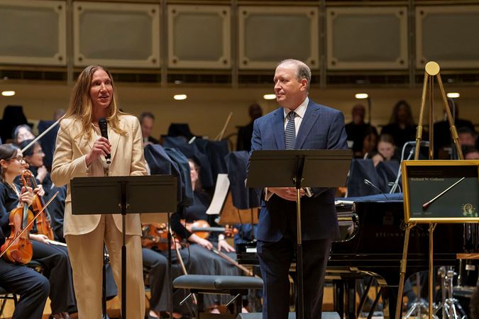 CSOA president Jeff Alexander and Melissa Root present Richard Colburn with the Excellence in Philanthropy Award on stage before the concert