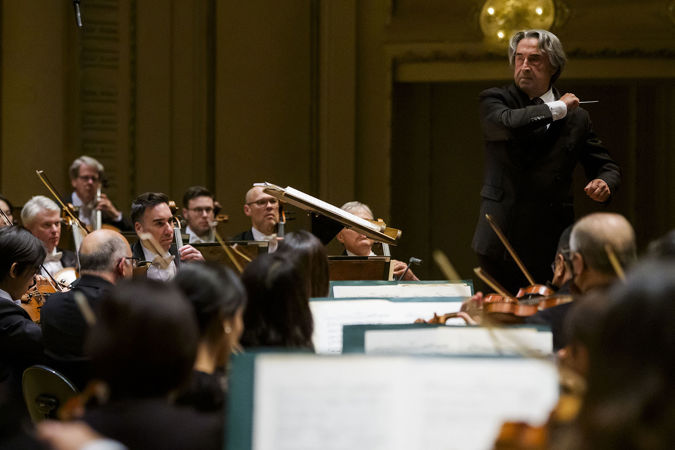 Riccardo Muti makes a striking gesture at the podium to emphasize a particular beat of music