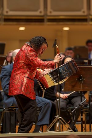Closeup action shot of Steelpan player and 2024 winner of the Crain-Maling Young Artists Competition Jaden Teague-Núñez performing with members of the CSO