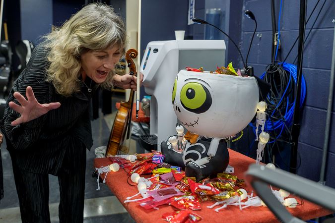 CSO viola Catherine Brubaker eyes a giant skeleton-shaped bowl of Halloween candy backstage