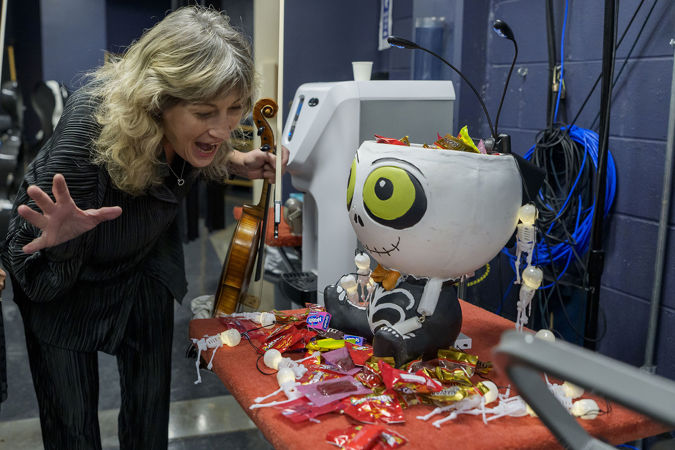 CSO viola Catherine Brubaker eyes a giant skeleton-shaped bowl of Halloween candy backstage
