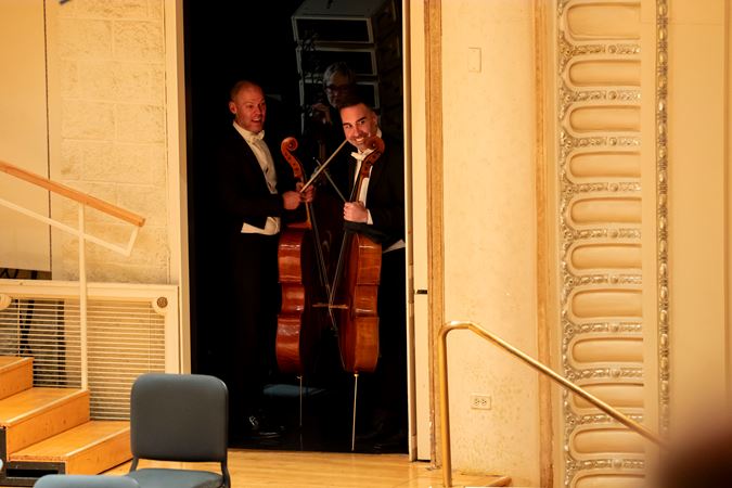 CSO cellos Brant Taylor and Kenneth Olsen standing at a side stage door