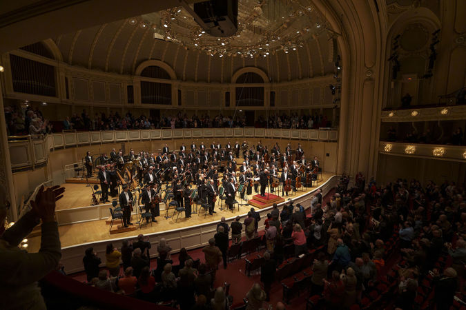 the audience rises to its feet as the orchestra and Jaap van Zweden take a collective bow on stage