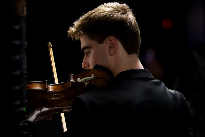 Closeup action shot of a Civic violinist warming up