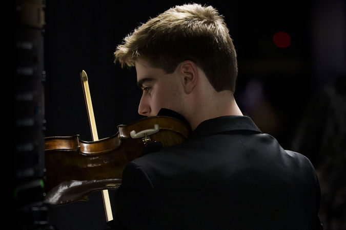Closeup action shot of a Civic violinist warming up