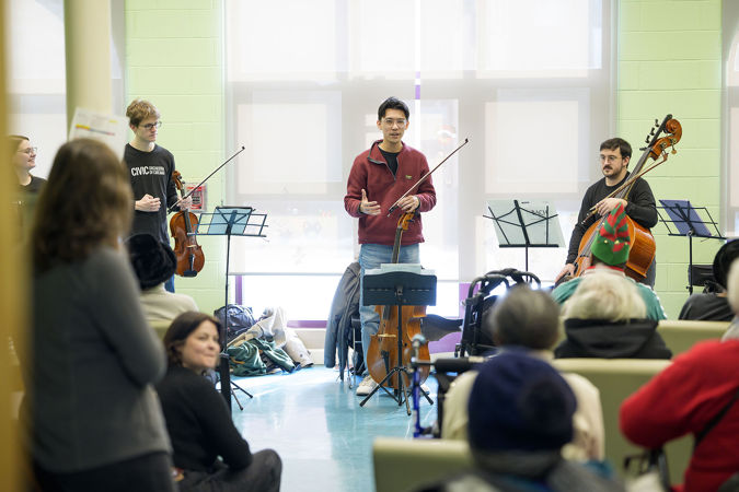 Civic cello Brandon Xu speaks with community members from Chicago Commons during the 2025 Bach Marathon concert