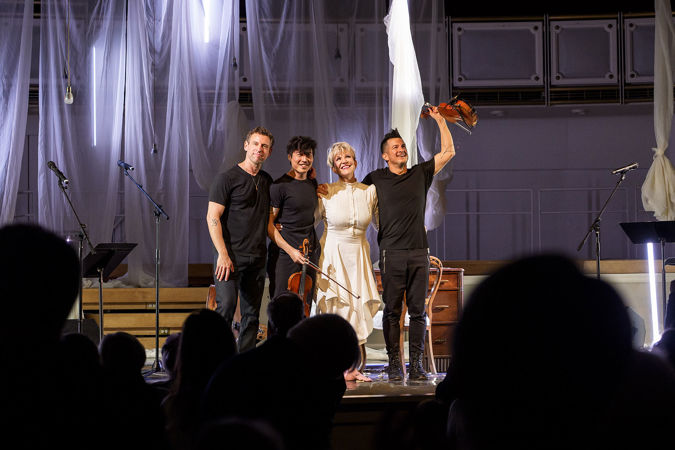 Joyce DiDonato and Time For Three huddle in the middle of the stage for a bow, all smiles as the crowd rises to its feet