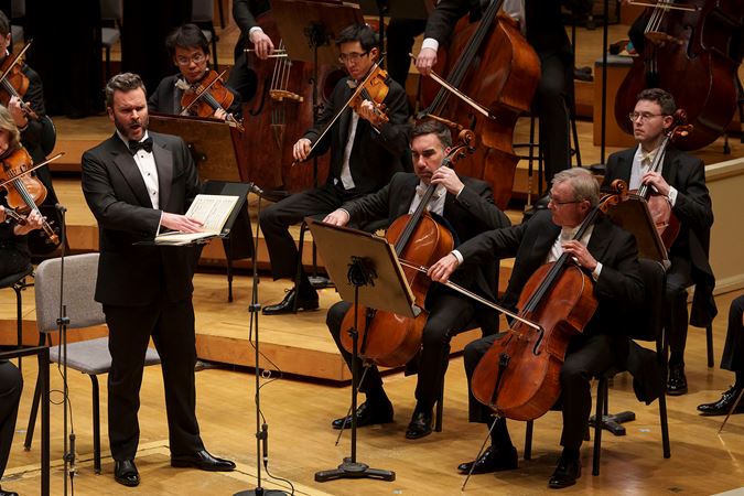 Close up of baritone Joshua Hopkins singing on stage
