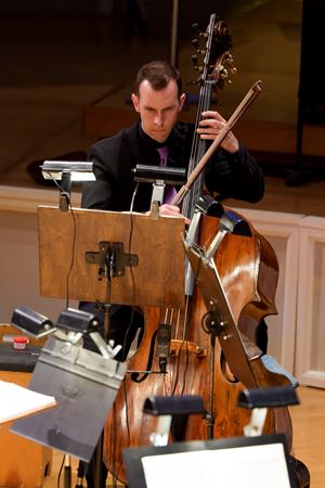 Closeup action shot of CSO principal bass Alexander Hanna performing on stage