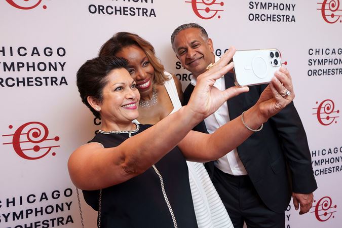 Singer Heather Headley takes photos with two fans postconcert