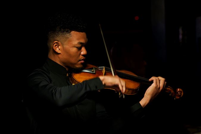 Closeup shot of violinist Randall Goosby warming up backstage before he solos with the CSO