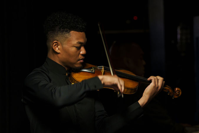 Closeup shot of violinist Randall Goosby warming up backstage before he solos with the CSO
