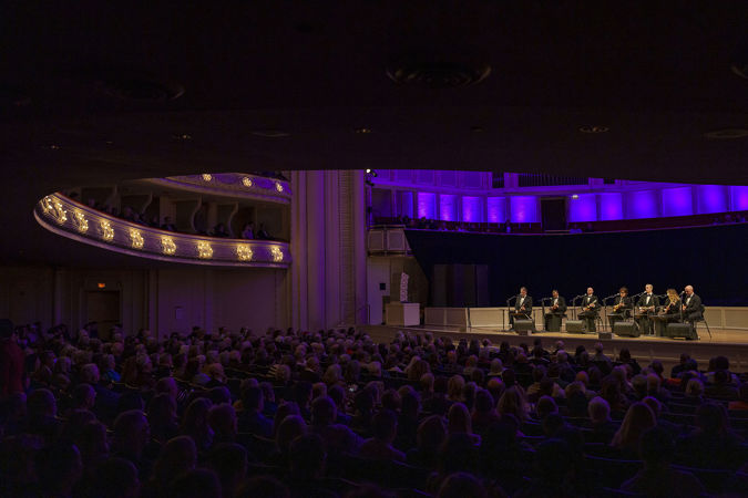 point of view from the back right side of the main floor as the audience watches, enraptured