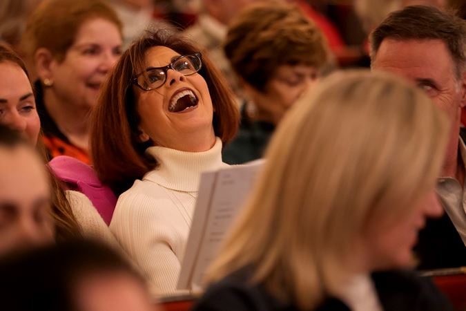 Closeup of a concert attendee singing a carol at a Merry, Merry Chicago! program