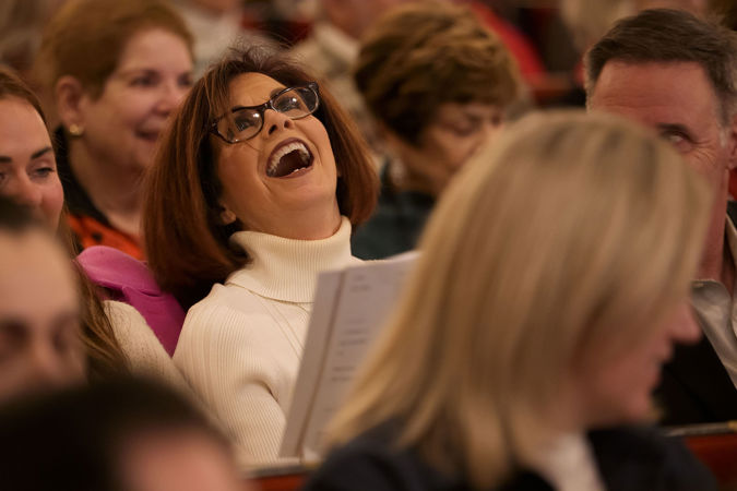 Closeup of a concert attendee singing a carol at a Merry, Merry Chicago! program