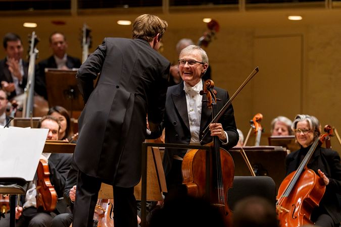Mäkelä shakes the hand of a smiling John Sharp, the CSO's principal cello, after an outstanding solo performance