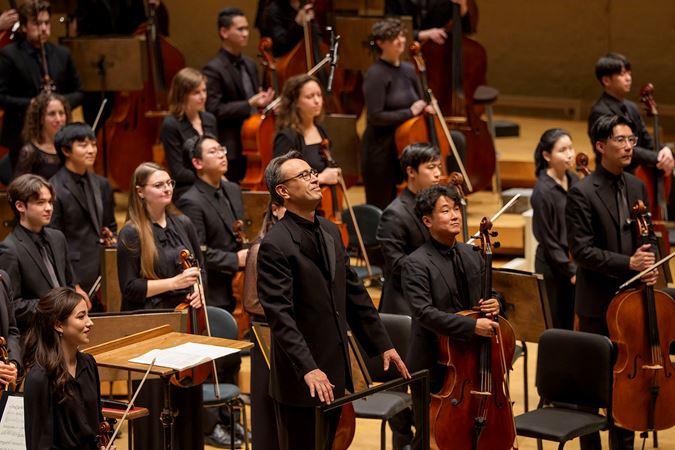 Group shot of principal conductor Ken-David Masur and Civic musicians bowing