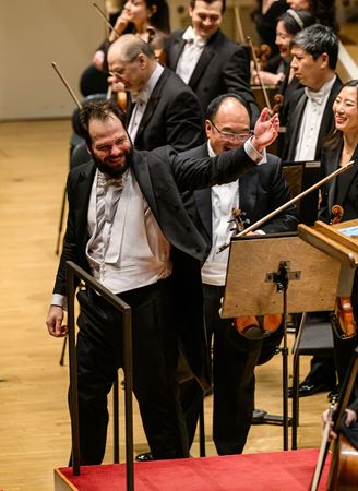 Petr Popelka gestures to the Orchestra to bow after the performance of Till Eulenspiegel
