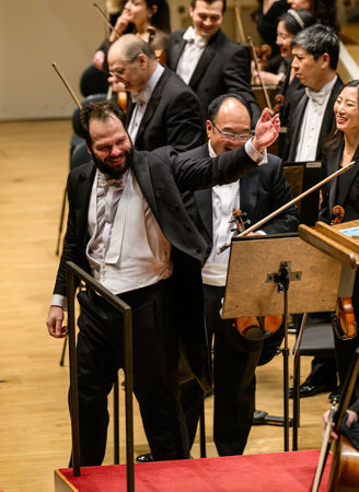 Petr Popelka gestures to the Orchestra to bow after the performance of Till Eulenspiegel