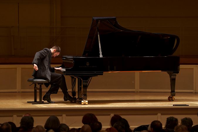 Alexandre Kantorow playing the piano on stage at his recital