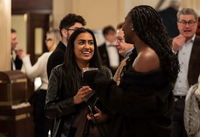Closeup of two smiling patrons chatting in the Main Floor lobby