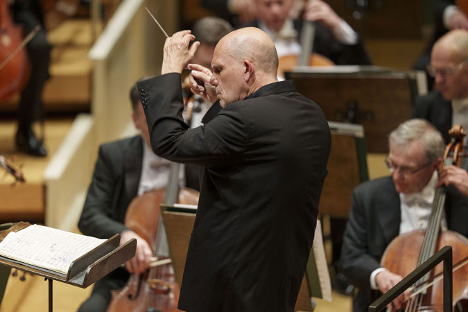 conductor Jaap van Zweden lifts his hands in a solemn gesture during Mahler's Seventh Symphony