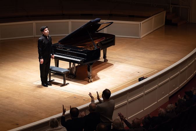 Behzod takes a bow as audience members in the front row begin to stand for an ovation