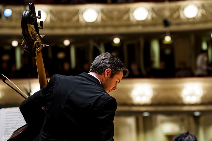 CSO bass Ian Hallas warms up on stage
