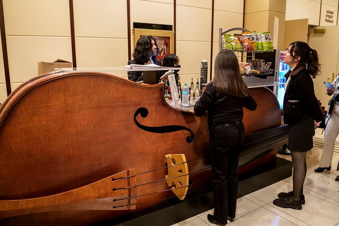 two young audience members order preconcert drinks and snacks at the giant bass-shaped bar in the Symphony Center Rotunda