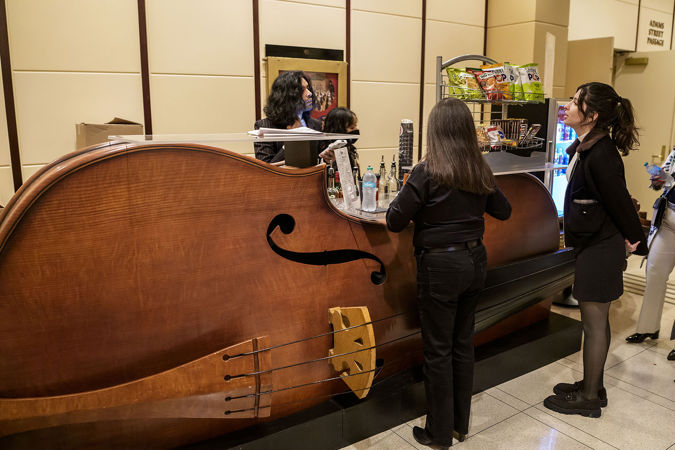 two young audience members order preconcert drinks and snacks at the giant bass-shaped bar in the Symphony Center Rotunda
