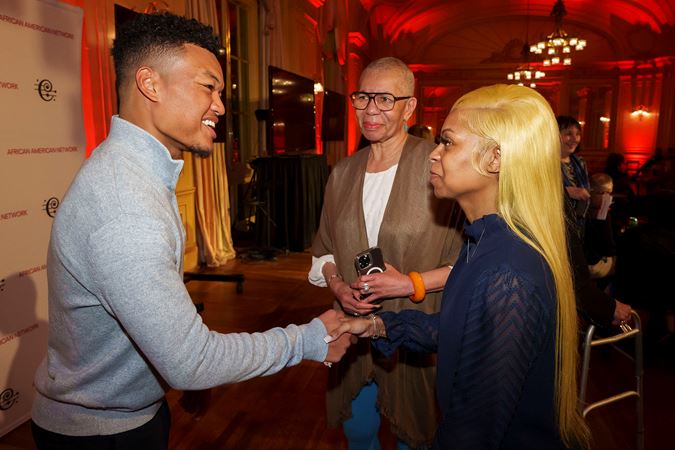 Violinist Randall Goosby speaking with two CSO African American Network members at a Meet-and-Greet postconcert event in Grainger Ballroom