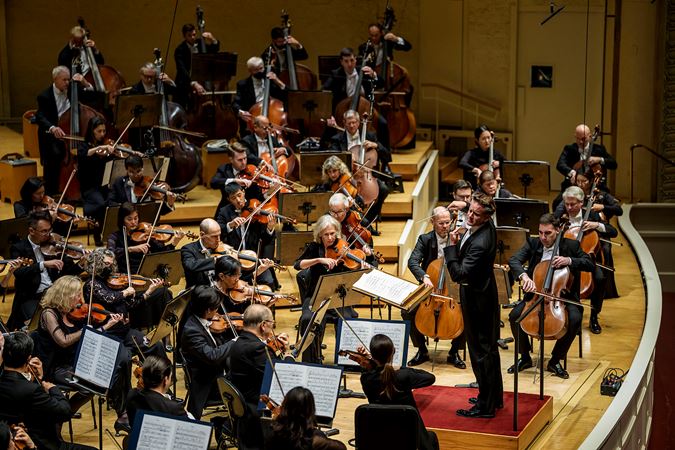 Action wide shot of guest conductor Philippe Jordan leading the CSO on stage
