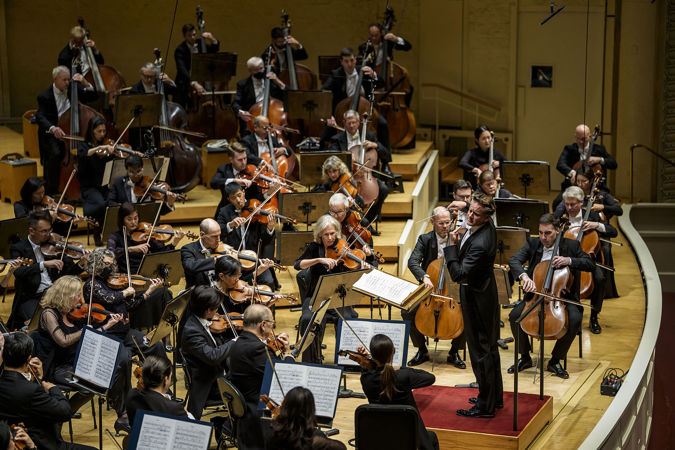 Action wide shot of guest conductor Philippe Jordan leading the CSO on stage