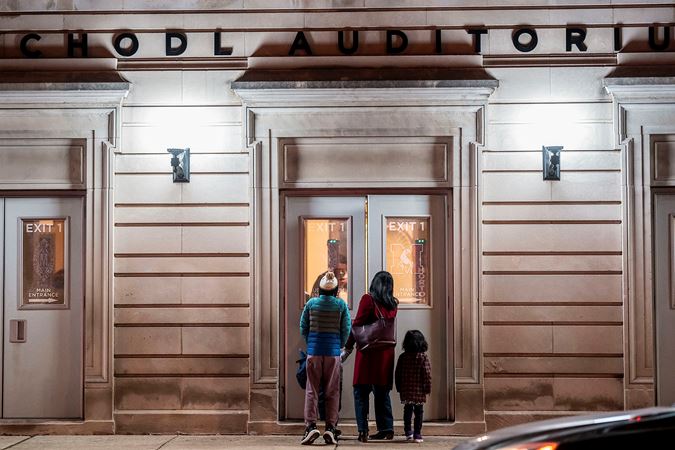 a family peers into the exterior doors of Chodl Auditorium