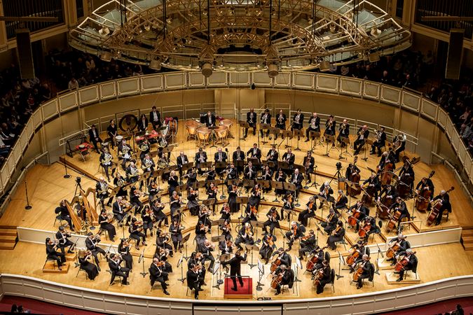 a wide shot from the lower balcony of Mäkelä and the Orchestra mid-performance