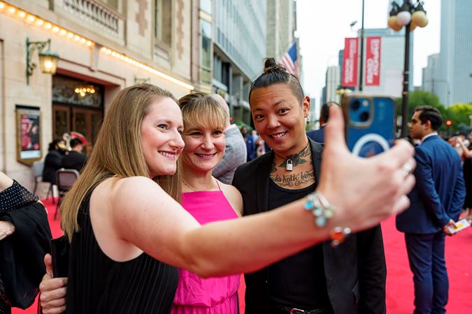 Symphony Ball patrons taking a selfie on the red carpet on Michigan Avenue