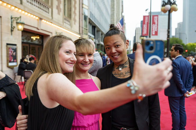 Symphony Ball patrons taking a selfie on the red carpet on Michigan Avenue
