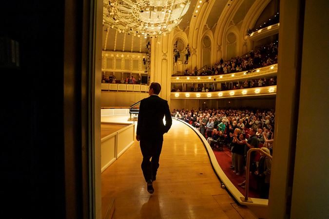 Víkingur Ólafsson walking on stage for his piano recital