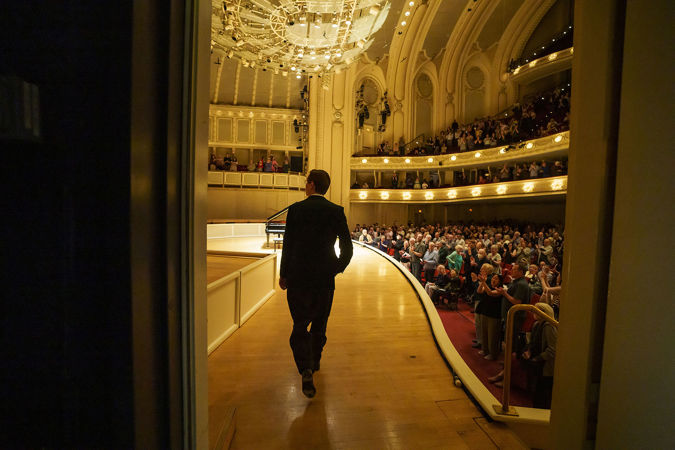 Víkingur Ólafsson walking on stage for his piano recital