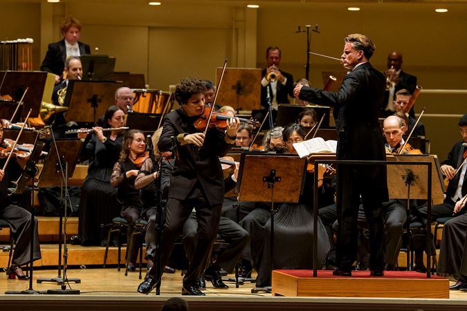 Closeup action shot of violin Augustin Hadelich performing on stage