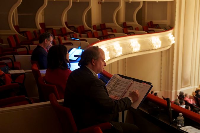 A side view of the four 2025 Young Artists Competition judges reading the score and taking notes on the Box Level