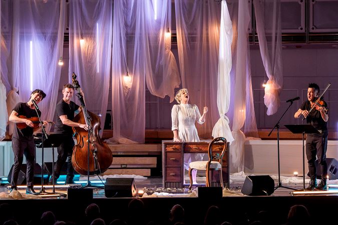 Time For Three sings and plays while Joyce DiDonato delivers a particularly powerful passage from behind a desk in the middle of the stage