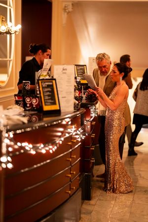 two audience members order drinks from the bar