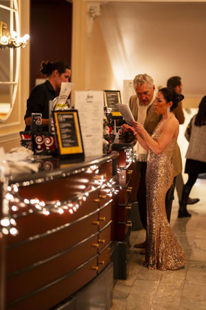 two audience members order drinks from the bar